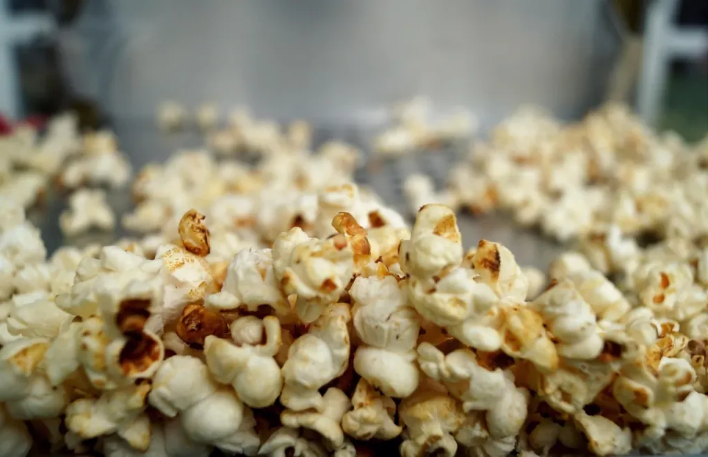 Projektor filmowy w przytulnym kinie domowym z popcornem i nastrojowym ekranem w tle, idealny do wieczornego seansu.