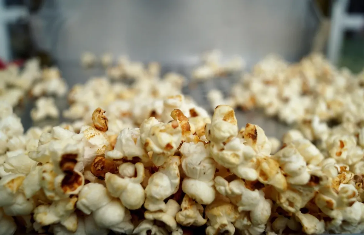 Projektor filmowy w przytulnym kinie domowym z popcornem i nastrojowym ekranem w tle, idealny do wieczornego seansu.