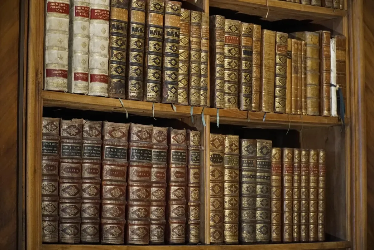 Rzędy starych książek na drewnianych półkach w bibliotece, podkreślające atmosferę wiedzy i tradycji.
